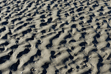 France; Bretagne. Plage de sable gris à maréz basse. Trace du retirement de l'eau laissant des mini dunes dans le sable. Brittany. Gray sand beach at low maréz. Trace of water retirement leaving mini 