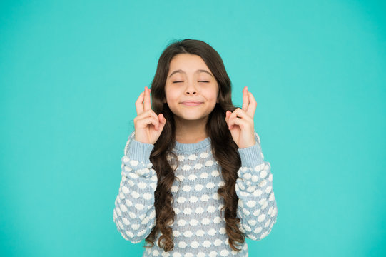 Full of hope. Child dream. Hopeful concept. Small child with long hair. Hope for best. Little child keep fingers crossed for luck. Believe in herself. Cute child make wish turquoise background