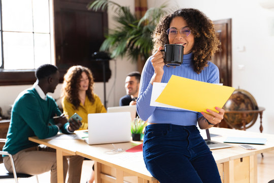 Portrait of a smiling woman in office with colleagues in background