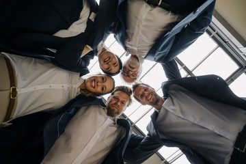 Happy business people huddling in office