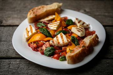 Vegetable salad on a white plate on a wooden background. Photo can be used for cafe or restaurant menu. There is a place for a logo or inscription.