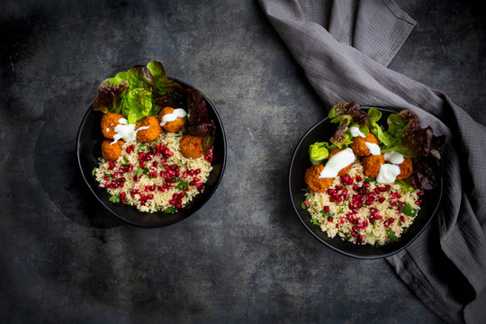 Bowls of?falafel?with lettuce, yogurt, pomegranate seeds, parsley, mint and Tabbouleh salad