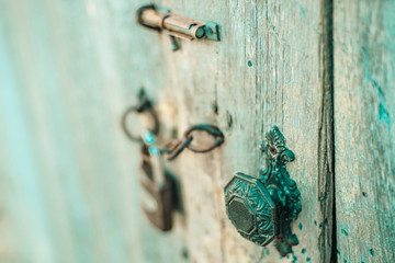 Old wooden door with a vintage handle, hook and lock. Boho style.