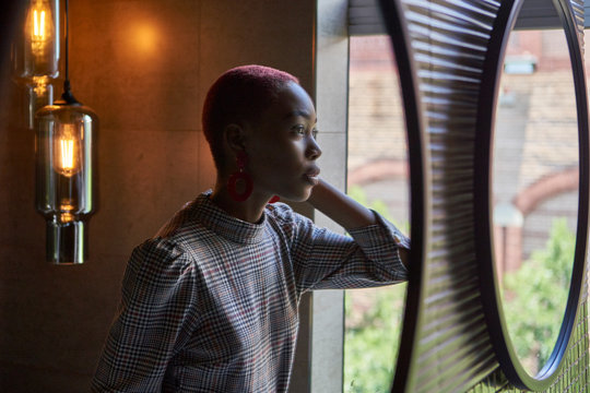 Young woman with short haircut looking to her reflection