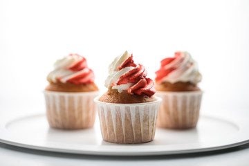 Three red and white cupcakes on a white background. There is a place for an inscription or logo