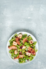 Healthy eating, grilled salmon, arugula, grapefruit and pomegranate on gray table, top view
