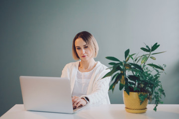 Happy Caucasian business woman working on laptop computer. Freelancer working remotely on Internet from home office. Online dating. Freelance, job, self-employment concept.