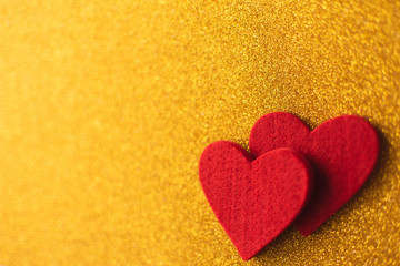 Red felt hearts on golden shiny background. Valentine's Day