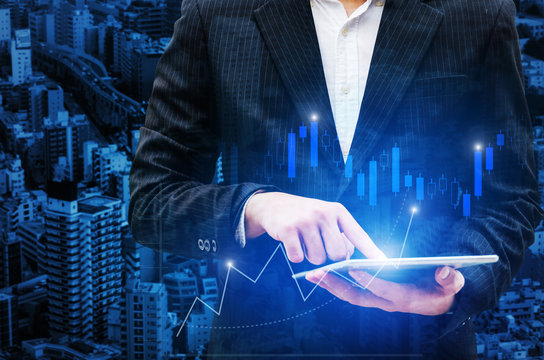young investor or smart businessman using digital mobile tablet with graphic candle stick graph chart of stock market investment for Forex trading, internet, investment, global business concept