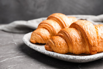 Tasty fresh croissants on brown marble table, closeup