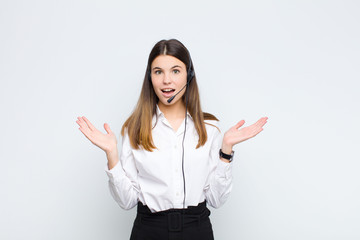 young pretty woman feeling happy, excited, surprised or shocked, smiling and astonished at...