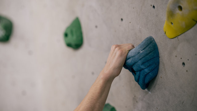 Mann beim Bouldern an Kletterwand