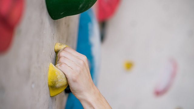 Mann beim Bouldern an Kletterwand