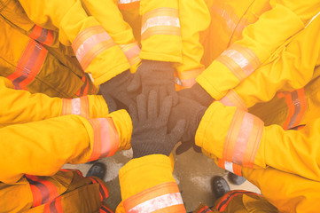 Firefighter putting hands up for fire fighting, Cheerful people giving strength motivation....