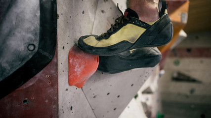 Mann beim Bouldern an Kletterwand