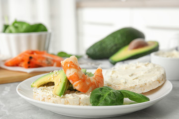 Puffed rice cake with shrimp and avocado on grey marble table indoors