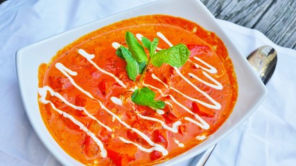 A dish of butter chicken tikka masala in red sauce at an Indian restaurant