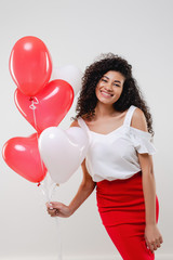 Fototapeta na wymiar bkack woman with colorful red heart shaped balloons isolated over white background
