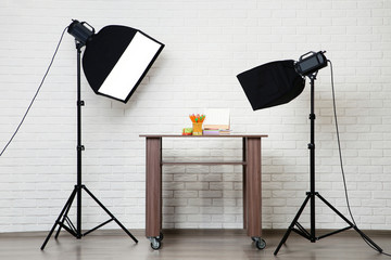 Photo studio with professional equipment shooting school supplies on table
