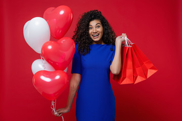 black woman with heart shaped colorful balloons and shopping bags on red background