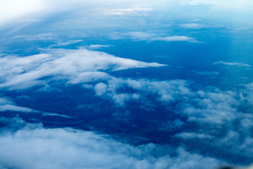 blue sky background with white clouds. Puffy clouds horizon. View from the airplane window. DARK BLUE CLOUDS BACKGROUND, NATURE BLUE SKIES. Atmosphere of Earth Sky Blue Daytime, Dark blue background