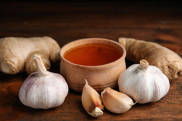 Fresh garlic and other natural cold remedies on wooden table