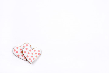 Two gingerbread cookies with frosting in the shape of a heart on white background. Valentines day concept. Flat lay, top view, copy space for text.