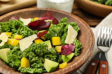 Delicious kale salad in wooden bowl, closeup
