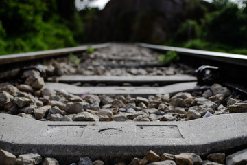 Vía del ferrocarril con piedras con montañas al fodso colo lo cercano enfoca y fondo desenfocado