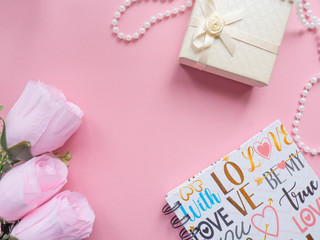 Background for Valentine's day. Copy space. Flat lay.  Gift box, necklace and flowers on pink background. In the center it is a place for text. 