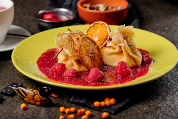 Crepes With Berries. pancakes with fresh berries, raspberries, strawberry, seabuckthorn and orange. Yummy pancake on the table, top view. Russian kitchen