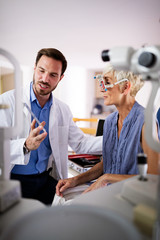 Optometrist examining senior woman in modern ophthalmology clinic