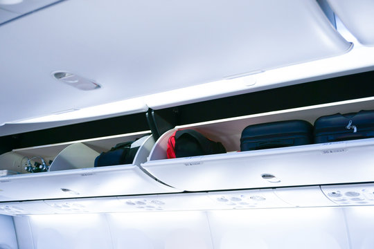Airplane cabine with the luggage compartments,luggage ready for departure on board aircraft