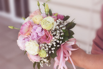 Lovely bridal bouquet of light pink ranunculus, pink and white wedding flowers and lots of green leaves fine toned in a gentle color