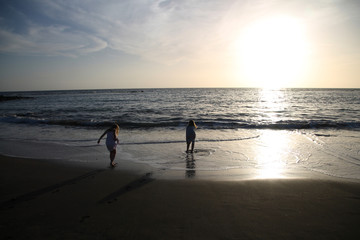 Children playing on the beach in sunset