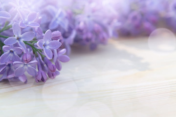 Beautiful floral blank for design - a border of lilac flowers on a wooden table with copy space for text