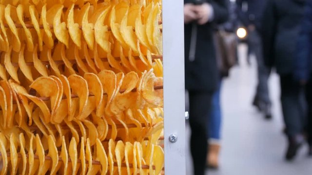 Interesting potato chips strung on skewers. Christmas stall with potato or apple chips.