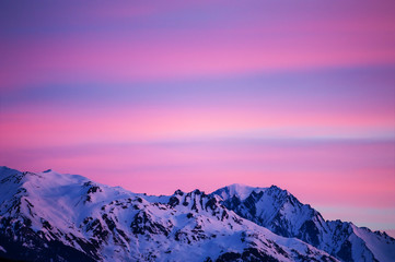 Fototapeta na wymiar Beautiful sunrise in the mountains, pink clouds in the sky. Winter Alps, France.