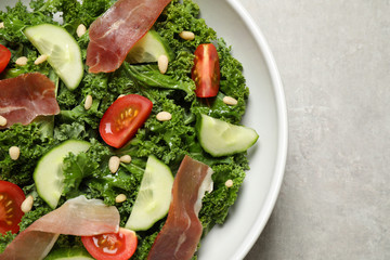 Delicious kale salad on grey table, top view