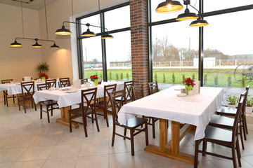 Cafe interior with tables for six and pendant lights