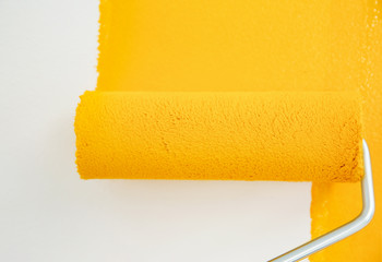 Obraz premium Painting white wall with yellow dye, closeup. Interior renovation