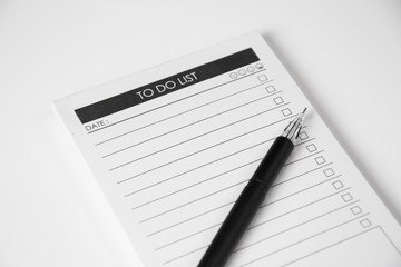 Blank to do list planner with checklist and black pen on white background, close up