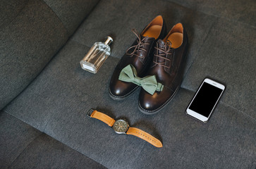Gentleman's, wedding man's set: perfumes, shoes, watches, bow tie, smartphone. Wedding details. Morning businessman. Photography, concept. Top view.