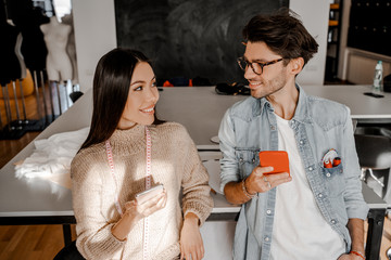 At first glance, the guy and the girl creative designers in the studio look at each other, distracted from everyday affairs and social networks. Real-world communication, modern lifestyle