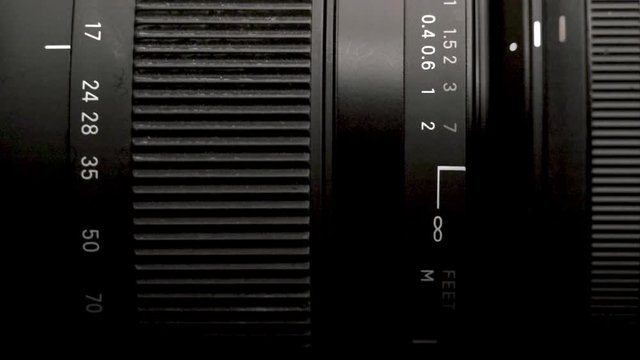 Close-up of a modern camera lens, turning of a zoom rings in shallow depth of field