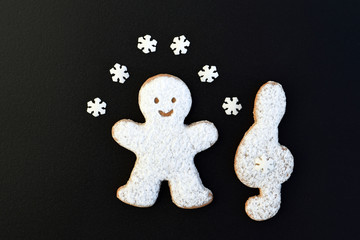 Music creative concept with sugared cookies - man and treble clef, decorated with small sugar snowflakes