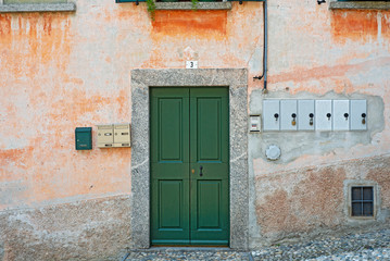 Fototapeta na wymiar Old weathered grunge house. Green wooden door.