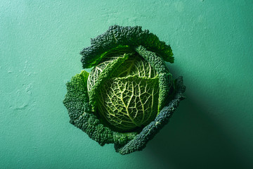 One cabbage on green background. Savoy cabbage. Healthy eating