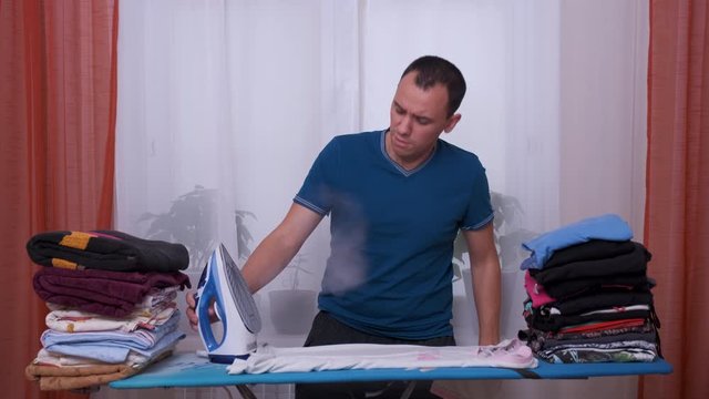 man ironing with dopey confused shocked look.