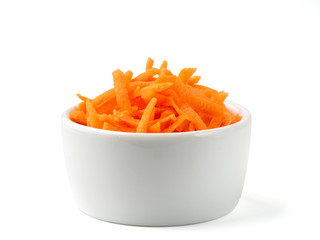Fresh organic shredded carrots in small white bowl. Raw grated carrots isolated on white with clipping path.